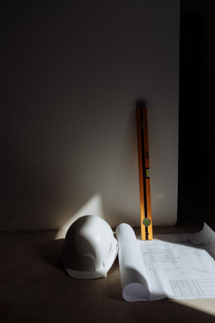 Services A hard hat, level, and blueprints in a construction setting, highlighting precision.